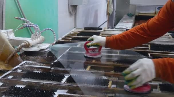 Uma fábrica de vidro de trabalho.O homem remove o chanfro no vidro . — Vídeo de Stock