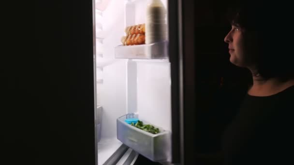 Night yet no one sees the woman stealthily takes the cake out of the fridge. — ストック動画