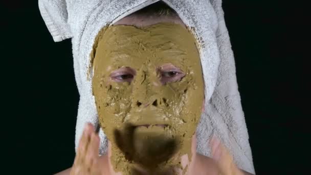 Dziewczyna w alginistycznej masce i ręcznik na głowie dotyka jej twarzy dłońmi. — Wideo stockowe