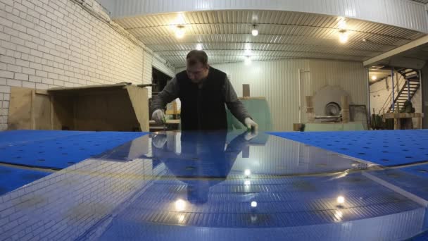Человек на заводе режет стекло стеклорезом на столе . — стоковое видео