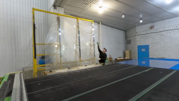 Pracovník hodí skleněnou tabulku z regálu na řezný stůl Cnc. — Stock video