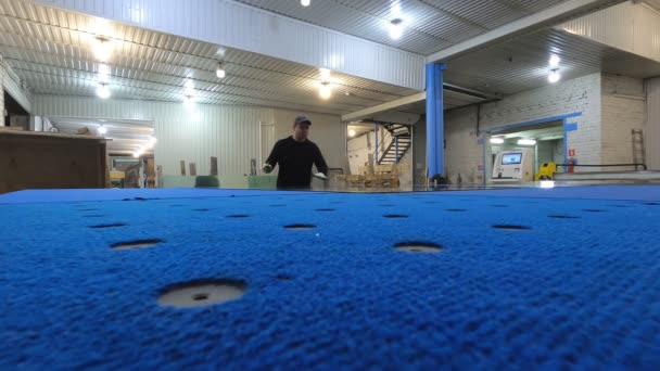 Travailler à l'usine de verre coupe la feuille sur la table bleue pour la surdécouper . — Video