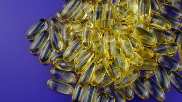 Omega 3 fatty acids in capsules Golden brown rotating on the table. — Stockvideo