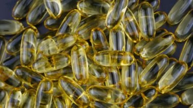 Gold capsules with omega 3 fish oil closeup.