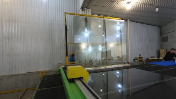 Trabajadores de una mesa de enrutador de vidrio cortado en fábrica. para cortar hojas de vidrio . — Vídeos de Stock