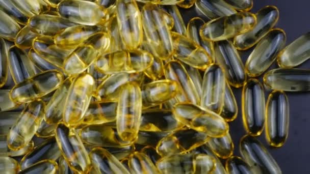 De nombreuses capsules d'oméga 3 se rapprochent des comprimés et brouillent le fond . — Video