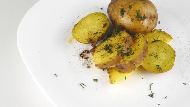 Kartoffeln in der Schale, die sich auf einem weißen Teller drehen.. — Stockvideo