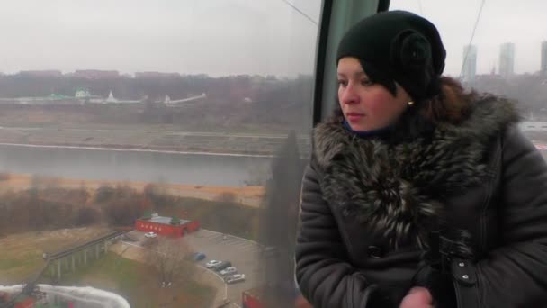 Femme monte dans la cabine le téléphérique et regarde par la fenêtre . — Video