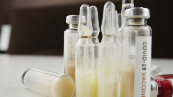Många ampuller och injektionsflaskor med vaccin samt tester för coronavirus nCoV. — Stockvideo