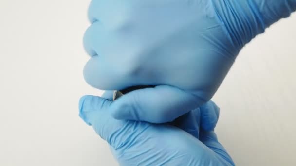 Händerna i blå medicinska handskar twist grinder fylld med marken marijuana. — Stockvideo