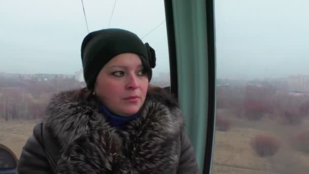 Frau mit Hut und Pelzmantel fährt zur Kabine der Seilbahn. — Stockvideo