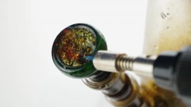 Beyaz bir arka planda, yakın çekimde yanan ve yanan marihuana..