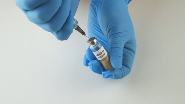 Le vaccin contre le coronavirus nCoV.Mains avec des gants tenant une seringue et un flacon . — Video