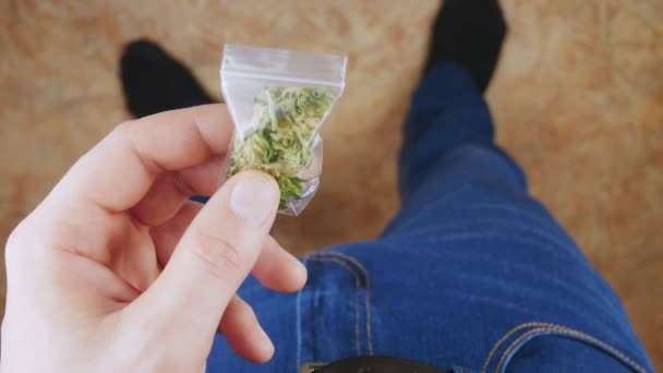 Homme méconnaissable en jeans tenant un sac rempli de marijuana médicale . — Video