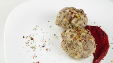 Köfteler buharda pişmiş. Domates soslu iki köfte..