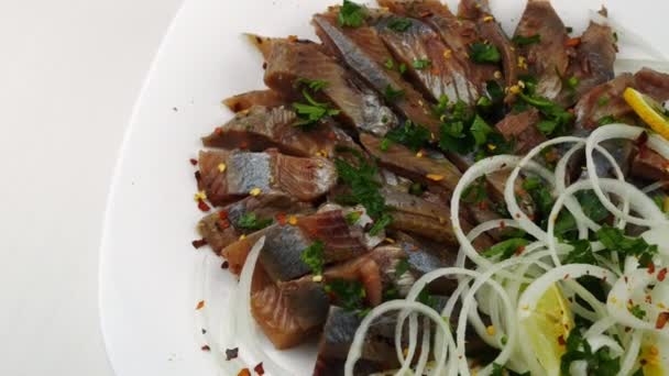 Fillet of salted herring with onions and lemon,sprinkled with parsley. — Stock Video