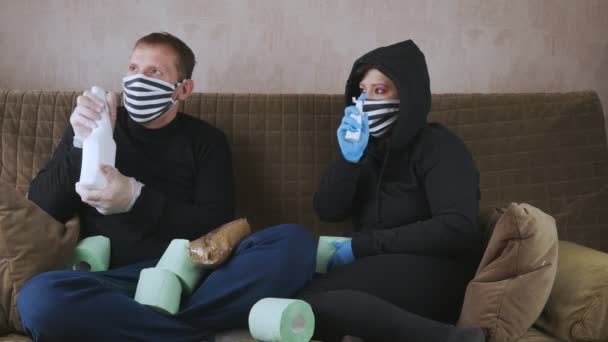 O casal em quarentena. No sofá esguicha anti-séptico ao redor . — Vídeo de Stock