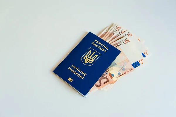 Pasaporte de Ucrania con Euro Bills dentro. Sobre un fondo blanco con monedas de relleno . —  Fotos de Stock