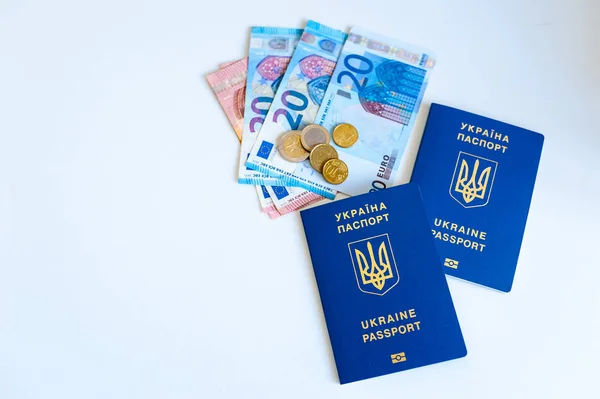 Pasaporte de Ucrania con Euro Bills dentro. Sobre un fondo blanco con monedas de relleno . —  Fotos de Stock