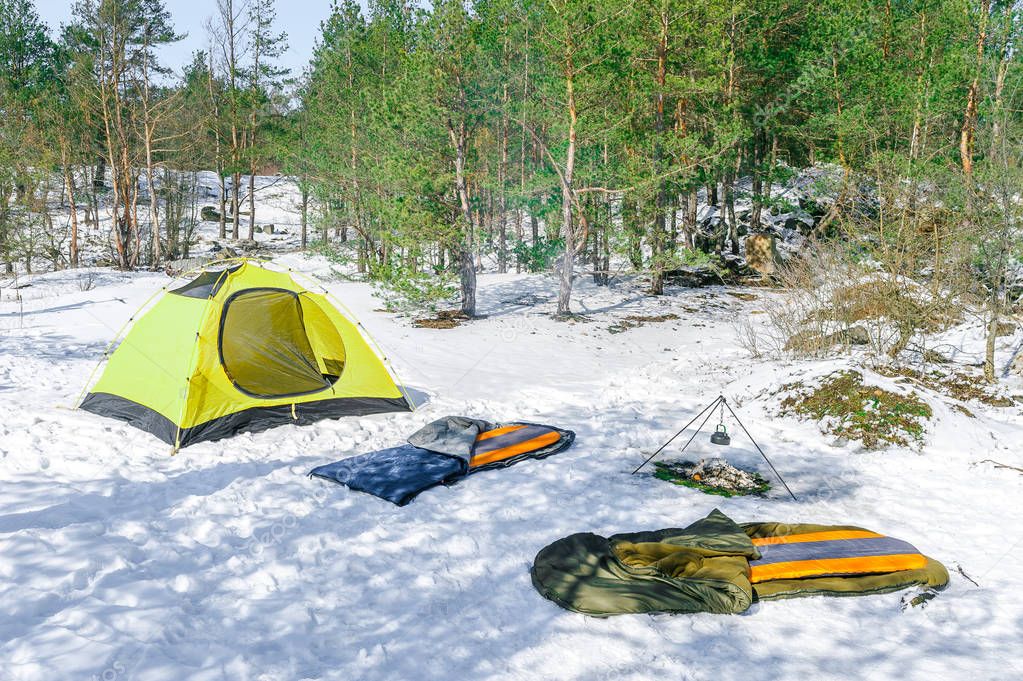 Outdoor the sleeping pad and bag near yellow tent in winter