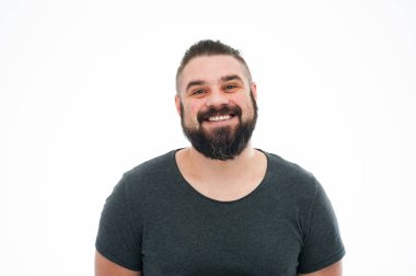 Sevinçle gülümseyen stüdyo çekim mavi t-shirt, kamera geniş bir gülümseme ile seyir Avrupa erkek modeli sakallı. Olumlu duygular, duygu ve reaksiyon