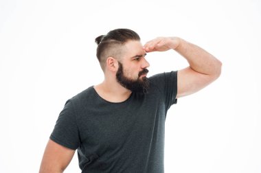 Bir konsantre portresi adam sırt çantası taşıyan ve beyaz arka plan üzerinde uzak izole seyir ekose gömlekli sakallı