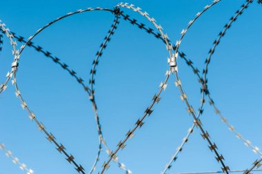 Hapishanede barbwire veya mavi gökyüzü arka plan ile diğer korunan nesne arasında asılı güvenlik kamerası yakından görünümü. Modern denetim yöntemleri. Güvenlik ve güvenlikte yeni teknolojiyi kullanma.