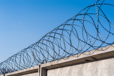 Hapishanede barbwire veya mavi gökyüzü arka plan ile diğer korunan nesne arasında asılı güvenlik kamerası yakından görünümü. Modern denetim yöntemleri. Güvenlik ve güvenlikte yeni teknolojiyi kullanma.