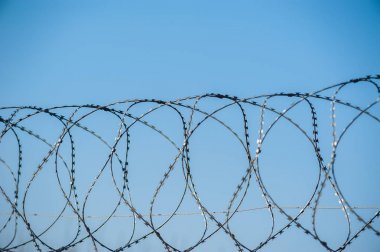 Hapishanede barbwire veya mavi gökyüzü arka plan ile diğer korunan nesne arasında asılı güvenlik kamerası yakından görünümü. Modern denetim yöntemleri. Güvenlik ve güvenlikte yeni teknolojiyi kullanma.