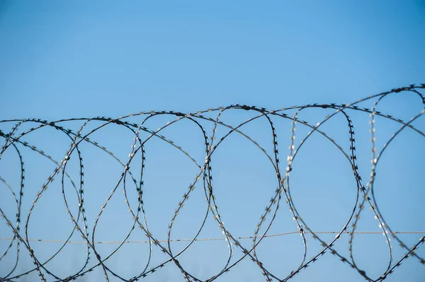 Hapishanede barbwire veya mavi gökyüzü arka plan ile diğer korunan nesne arasında asılı güvenlik kamerası yakından görünümü. Modern denetim yöntemleri. Güvenlik ve güvenlikte yeni teknolojiyi kullanma.