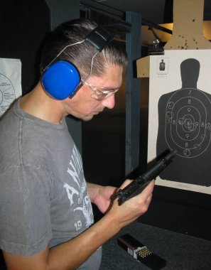 Bir adam bir tabanca yeniden yükler. Atış poligonuna. Hedef