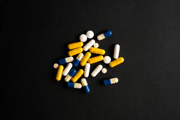 Different tablets, pills, medications drugs on black background — Stock Photo, Image