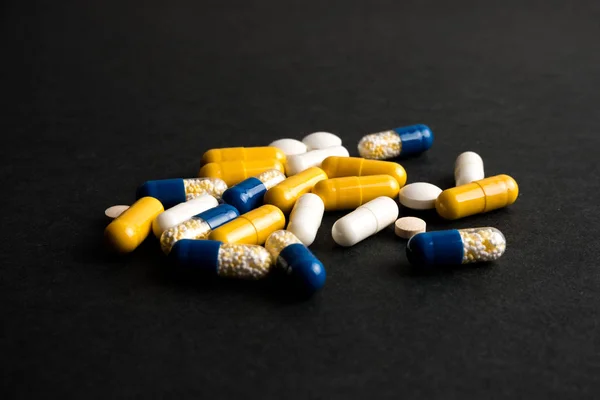 Különböző tabletták, tabletták, gyógyszerek fekete alapon Stock Kép