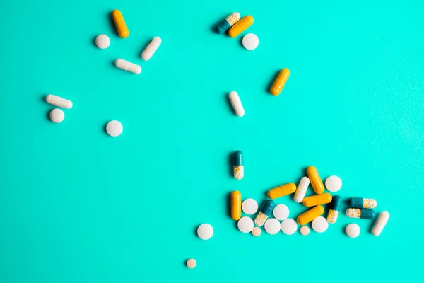 Diferentes comprimidos, comprimidos, medicamentos drogas em fundo turquesa — Fotografia de Stock