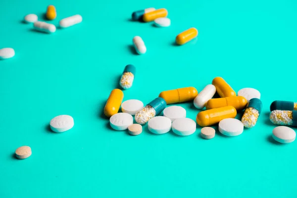 Таблетки, таблетки, лекарства на бирюзовом фоне — стоковое фото