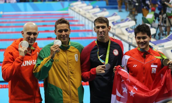 Laszlo Cseh HUN (L), Chad le Clos RSA, Michael Phelps USA and Joseph Schooling SGP during medal ceremony after men 's 100 m butterfly of the Rio 2016 Olympics — стоковое фото