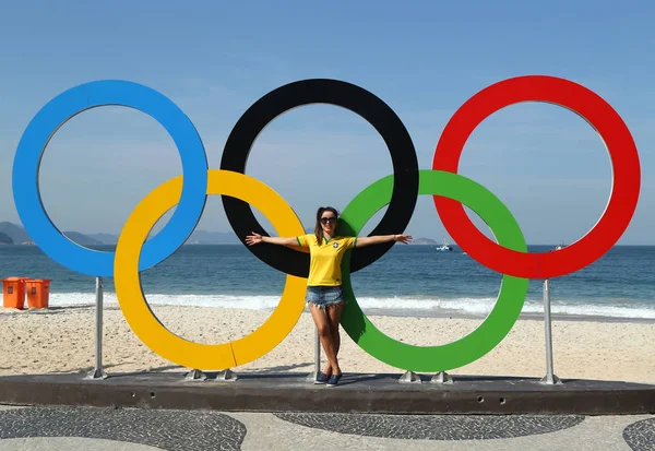 Turista brasileño tomando fotos de los anillos olímpicos en la playa de Copacabana en Río de Janeiro —  Fotos de Stock