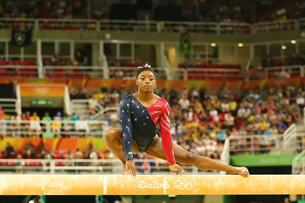 Олимпийская чемпионка Симона Байлз из США, соревнующаяся на бревне на квалификации по многоборью среди женщин — стоковое фото