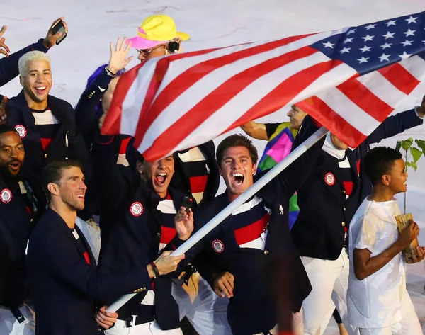 Олимпийский чемпион Майкл Фелпс с флагом США, ведущий олимпийскую сборную США на церемонии открытия Рио-2016 — стоковое фото