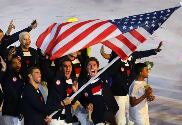 Olympiasieger michael phelps trägt die Flagge der Vereinigten Staaten, die das olympische Team USA bei der Eröffnungsfeier in Rio 2016 anführt — Stockfoto