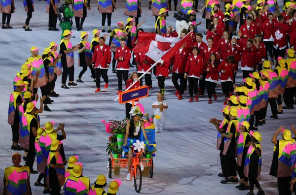 Gimnasta olímpica campeona de trampolín Rosie MacLennan portando bandera canadiense liderando el equipo olímpico de Canadá en la ceremonia de apertura de Río 2016 —  Fotos de Stock