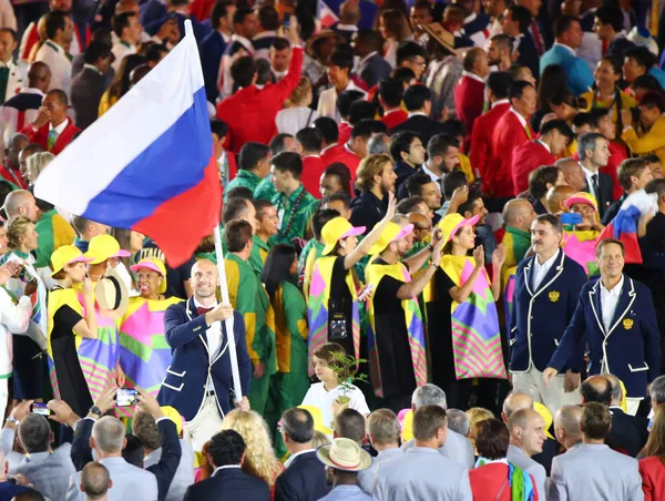 Volleyballspieler Sergey Tetjuchin mit der russischen Fahne an der Spitze der russischen Olympiamannschaft bei der Eröffnungszeremonie in Rio 2016 — Stockfoto