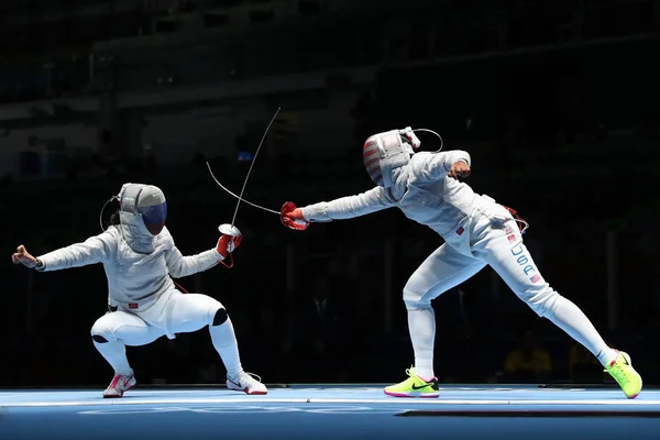 Ibtihaj Muhammad de Estados Unidos (R) y Sofya Velikaya de Rusia compiten en el Equipo Femenino Sabre de los Juegos Olímpicos de Río 2016 — Foto de Stock