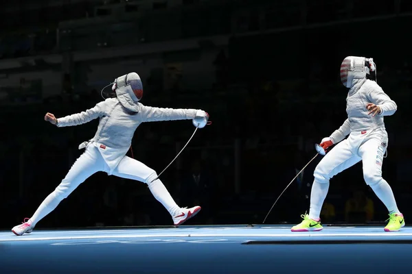 Ibtihaj Muhammad de Estados Unidos (R) y Sofya Velikaya de Rusia compiten en el Equipo Femenino Sabre de los Juegos Olímpicos de Río 2016 — Foto de Stock