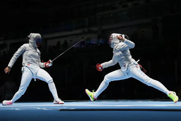 Ibtihaj Muhammad de Estados Unidos (R) y Sofya Velikaya de Rusia compiten en el Equipo Femenino Sabre de los Juegos Olímpicos de Río 2016 — Foto de Stock