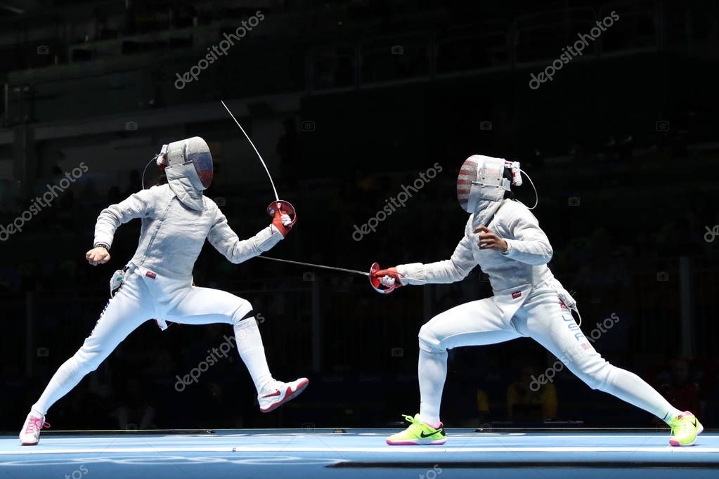 RIO DE JANEIRO, BRAZIL - AUGUST 13, 2016: Ibtihaj Muhammad of United States (R) and Sofya Velikaya of Russia compete in the Womens Sabre Team of the Rio 2016 Olympic Games at Carioca Arena 3