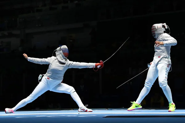 Ibtihaj Muhammad de Estados Unidos (R) y Sofya Velikaya de Rusia compiten en el Equipo Femenino Sabre de los Juegos Olímpicos de Río 2016 — Foto de Stock