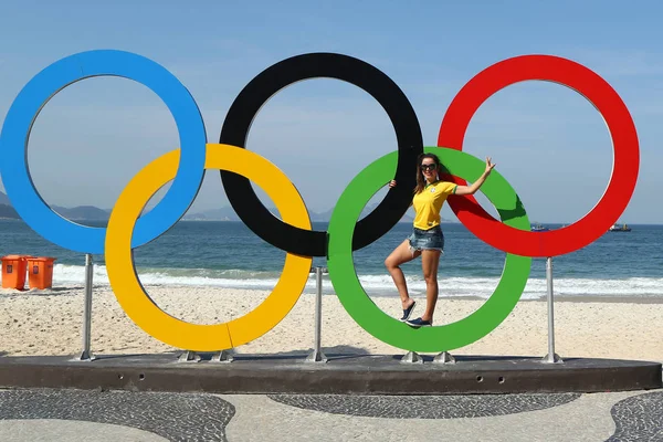 Turista brasileño tomando fotos de los anillos olímpicos en la playa de Copacabana en Río de Janeiro —  Fotos de Stock