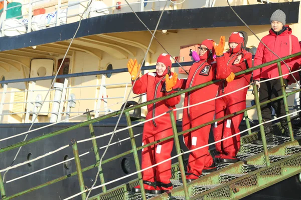 Oidentifierade turister laddade upp med en överlevnad kostym redo till is simma i frysta Östersjön. — Stockfoto