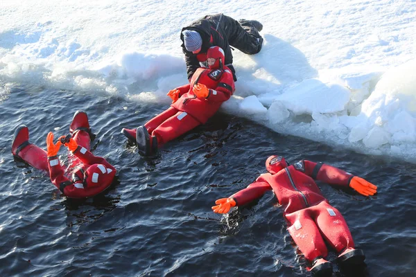Oidentifierade turister inriktade upp med ett survival suit is dopp i frysta Östersjön. — Stockfoto